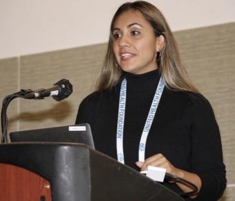 Elizabeth Rojo speaking at a podium with a microphone
