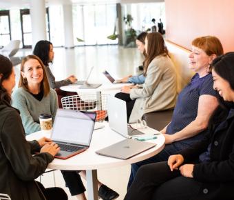 UPIEA team around a table with papers and computers in discussion