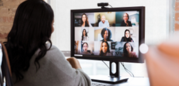person at computer talking to a group of people on screen