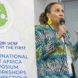 A person speaking in front of a banner stating: USL & QBI Present the first International West Africa Symposium and Workshops